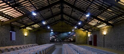 La nave de 1909 de la bodega Cvne, en la Rioja, con las cerchas metálicas que sujetan el techo ideadas en el taller de Eiffel, al fondo, la fotografía de José Manuel Ballester.