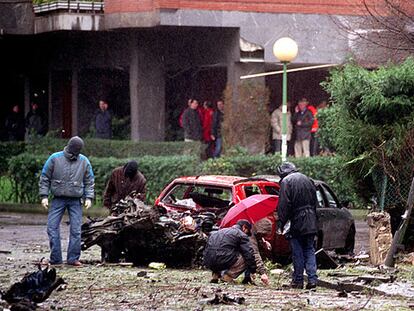 Agentes de la Ertzaintza inspeccionan los restos del coche bomba que ETA hizo explotar en Getxo.