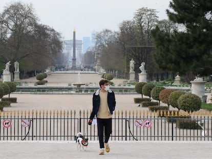 Un hombre pasea al perro en el jardín de las Tullerías, en París, el día que entra en vigor el confinamiento obligatorio.