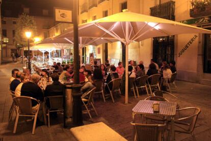 Un grupo de personas cena en una terraza en el centro de San Lorenzo de El Escorial.