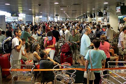 Cientos de personas hacan cola ayer en los mostradores del aeropuerto de El Prat para facturar las maletas.