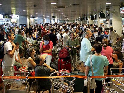 Cientos de personas hacían cola ayer en los mostradores del aeropuerto de El Prat para facturar las maletas.