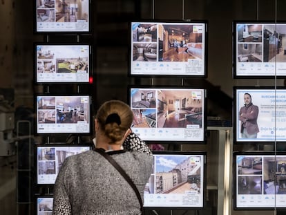 Una mujer mira anuncios de vivienda en una inmobiliaria de Barcelona, en una imagen de archivo.