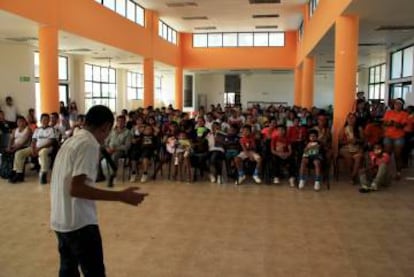 Arriba: Un grupo de mujeres waorani espera en la puerta de la Unidad Educativa del Milenio Yasuní. Abajo: Un estudiante de la Unidad Educativa del Milenio Yasuní canta frente a sus compañeros.