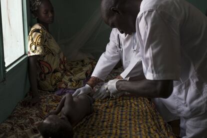 Un médico atiende a un paciente menor de cinco años en el hospital de Dioila.