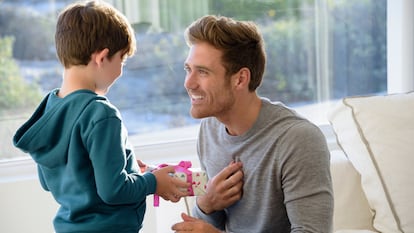 Un niño entregando un regalo a su padre.