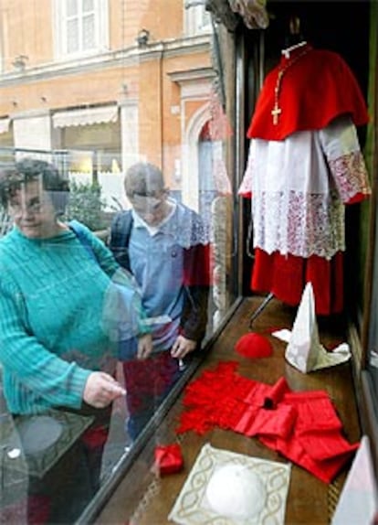 Dos turistas miran el escaparate de la tienda Gammarelli en Roma, que vende las indumentarias de los obispos.