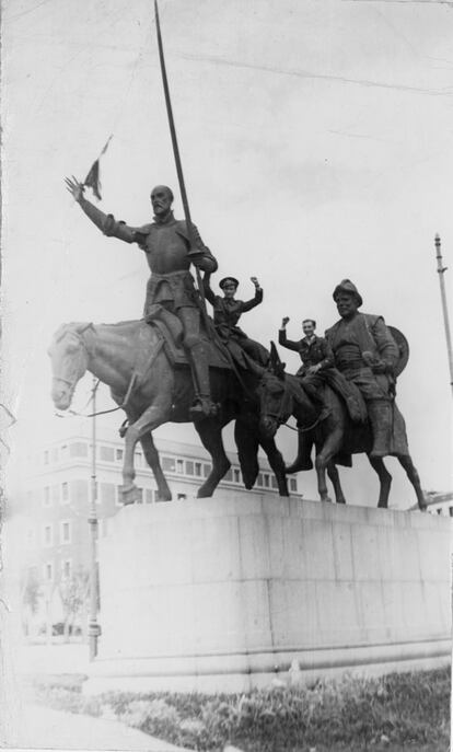 Imagen facilitada por el Ministerio de Cultura de dos miembros de las XI Brigada Internacional junto a la escultura de Don Quijote y Sancho Panza situada en la Plaza de España de Madrid.