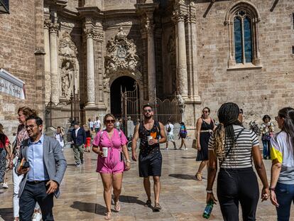 Turistas en la plaza de la Reina de Valencia, con la catedral de la ciudad al fondo.