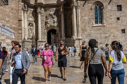 Turistas en la plaza de la Reina de Valencia, con la catedral de la ciudad al fondo.