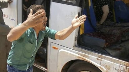Un hombre grita junto al autobús que transporta a un grupo de coptos atacado este viernes en las afueras de El Cairo.