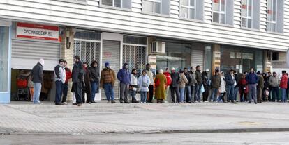 Varias personas hacen cola ante una oficina de empleo.