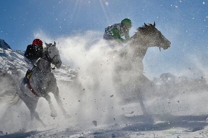 Varios participantes de la carrera de caballos de 1.600 metros en el evento White Turf, en St Moritz (Suiza).