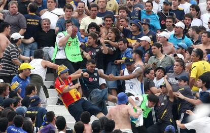 Aficionados de Boca Juniors agreden a guardias de seguridad en la grada.