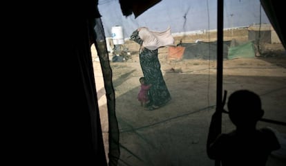 Fotografía de archivo tomada el 3 de junio de 2016 de una mujer siria y su hija en un asentamiento informal para refugiados en la frontera siria con Jordania.   