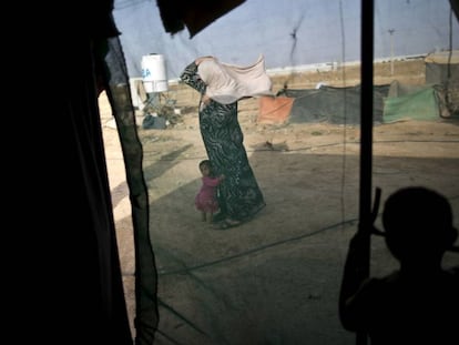 Fotografía de archivo tomada el 3 de junio de 2016 de una mujer siria y su hija en un asentamiento informal para refugiados en la frontera siria con Jordania.   