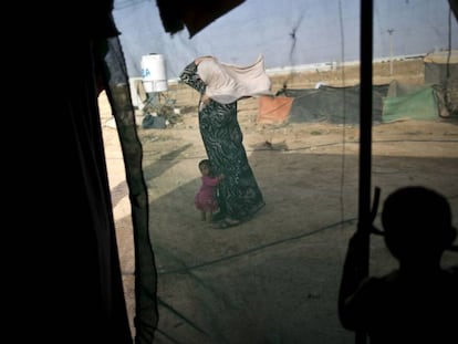 Fotografía de archivo tomada el 3 de junio de 2016 de una mujer siria y su hija en un asentamiento informal para refugiados en la frontera siria con Jordania.