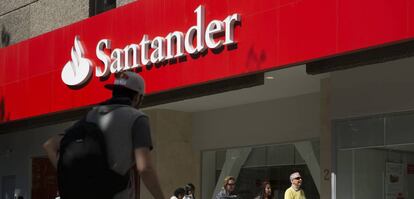 Varias personas pasan por delante de una oficina del Banco Santander.