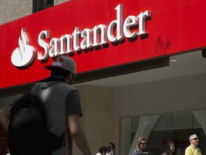 Varias personas pasan por delante de una oficina del Banco Santander.
