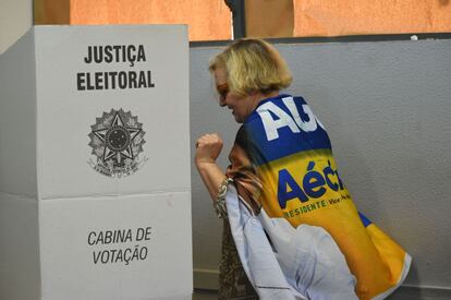 Uma mulher vai votar com a bandeira de campanha de Aécio, em Belo Horizonte, Minas Gerais.