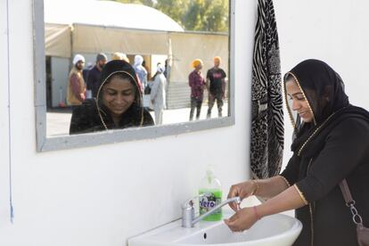 Una mujer india se lava las manos antes de entrar en el templo. La presencia de mujeres en los lugares de encuentro es poco frecuente.