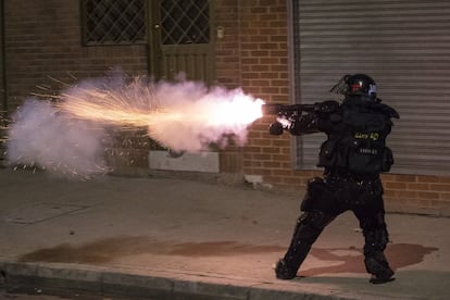 Un oficial de policía lanza gases lacrimógenos contra manifestantes. Al menos siete muertos en disturbios en Bogotá.