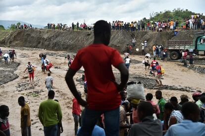 Haitian people cross the river La Digue in Petit Goave where the bridge collapsed during the rains from Hurricane Matthew, southwest of Port-au-Prince, October 6, 2016. 
Hurricane Matthew has left at least 23 people dead in Haiti, a toll likely to climb as authorities re-establish contact with the hardest-hit areas where the damage is "catastrophic," officials said. The Caribbean's worst storm in nearly a decade, Matthew slammed into Haiti, the Americas' poorest nation, with heavy rains and devastating winds triggering severe flooding and mud slides.
 / AFP PHOTO / HECTOR RETAMAL