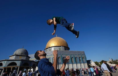 Un hombre palestino juega con un niño en las cercanías de la Cúpula de la Roca, en Jerusalén