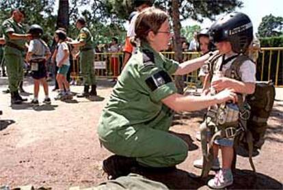 Una profesional de las Fuerzas Armadas vestía ayer a un niño con casco y arneses.