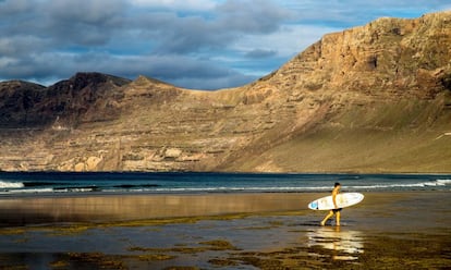 A surfer on Famara cove, on the Spanish island of Lanzarote.