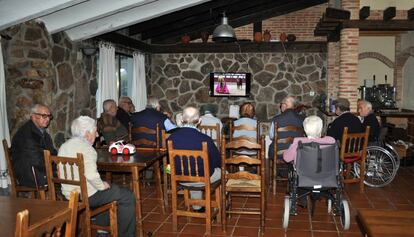 Un grup de persones grans, mirant la televisió en una residència.