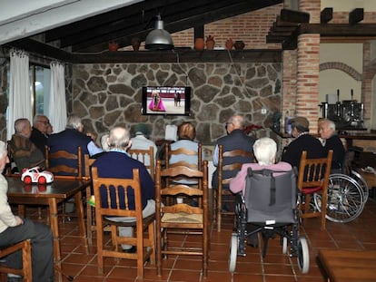 Un grupo de ancianos ven la televisi&oacute;n en una residencia