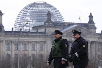 Dos agentes patrullan ante el edificio del Reichstag, sede del Parlamento alemán.