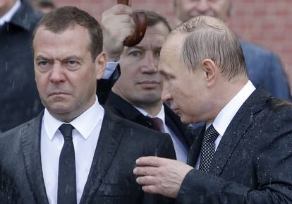 En la imagen, el presidente ruso Vladimir Putin habla con Dmitry Medvédev bajo la lluvia, junto al Kremlin en Moscú, el 22 de junio de 2017.