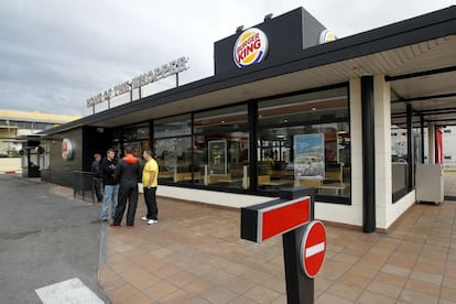 Varias personas conversan delante del Burguer King de Coslada.