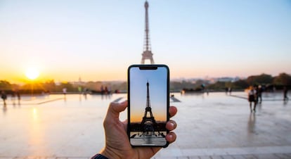 Un turista toma una foto de la Torre Eiffel.