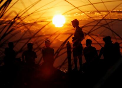 Un grupo de jóvenes filipinos disfruta de la puesta de sol en la bahía de Manila (Filipinas). 