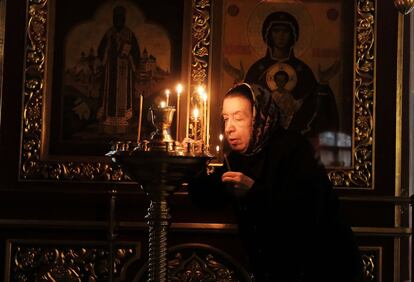 Una mujer enciende una vela en una iglesia ortodoxa en Moscú (Rusia).