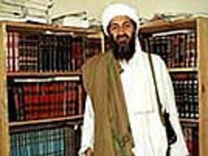 El terrorista Osama Bin Laden posa en abril de 1998 en Afganistan delante de unas estanterías de madera rústica con libros en lengua árabe.