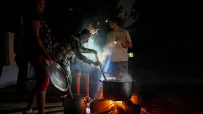 Several people prepare food in the street, lit by lanterns, on Saturday in Havana (Cuba).