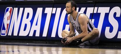 Ginobili calienta en la banda.