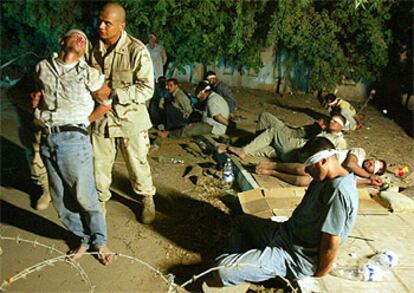Un soldado de EE UU traslada a un iraquí arrestado por posesión de armas en Bagdad.