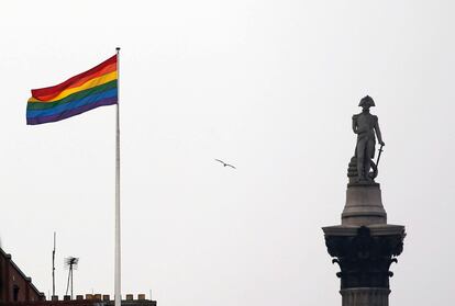 The rainbow flag flies over a building next to Nelson's Column