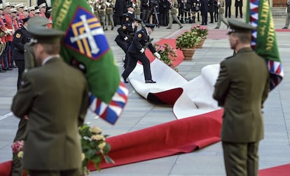 Soldados de la Guardia de Honor tratan de colocar la alfombra roja levantada por el viento durante una ceremonia para recibir al presidente chino, Xi Jinping, en el Castillo de Praga (República Checa).