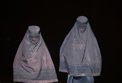 Dos mujeres afganas vestidas con burka salen de una tienda en un mercado en Mazar-i-Sharif.