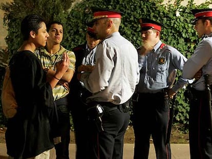 Agentes de los Mossos d'Esquadra conversan con unos ciudadanos en su primer día de despliegue en Barcelona.