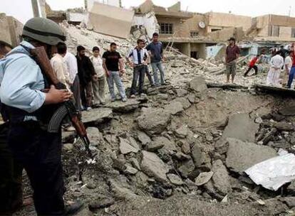 Policías y civiles miran el cráter causado por la explosión de las bombas en Bagdad.