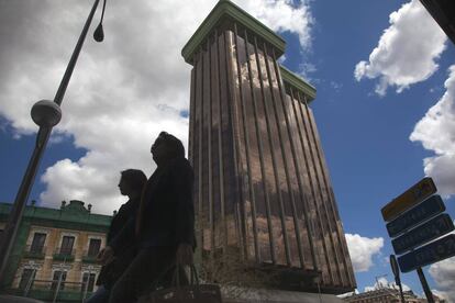 Dos personas pasan junto a las Torres Colón.