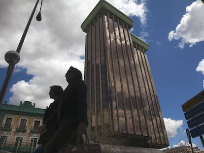 Dos personas pasan junto a las Torres Colón.