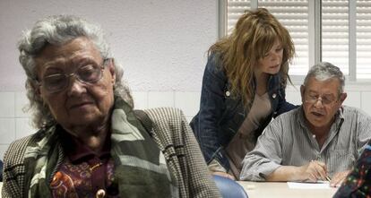 Raquel ayuda a su padre enfermo de alzhéimer, en un taller de la asociación de familiares.